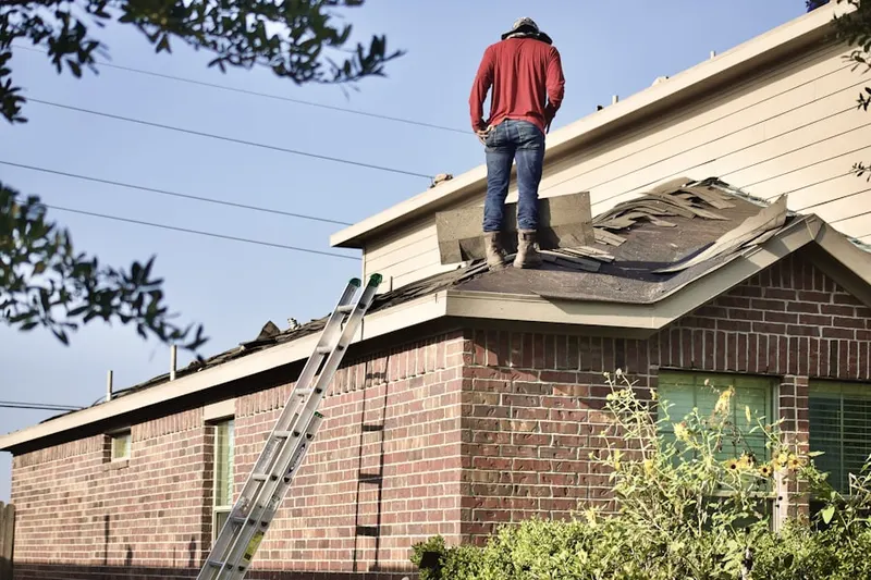 Professional roofer working on a residential roof in Marshfield Hills